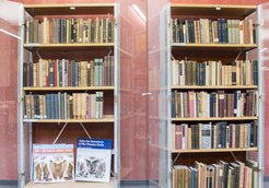 Open glass display cases containing antique books.
