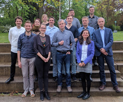 A group of people who took part in the Somatosensory Group Retreat, standing on outdoor steps, surrounded by trees.